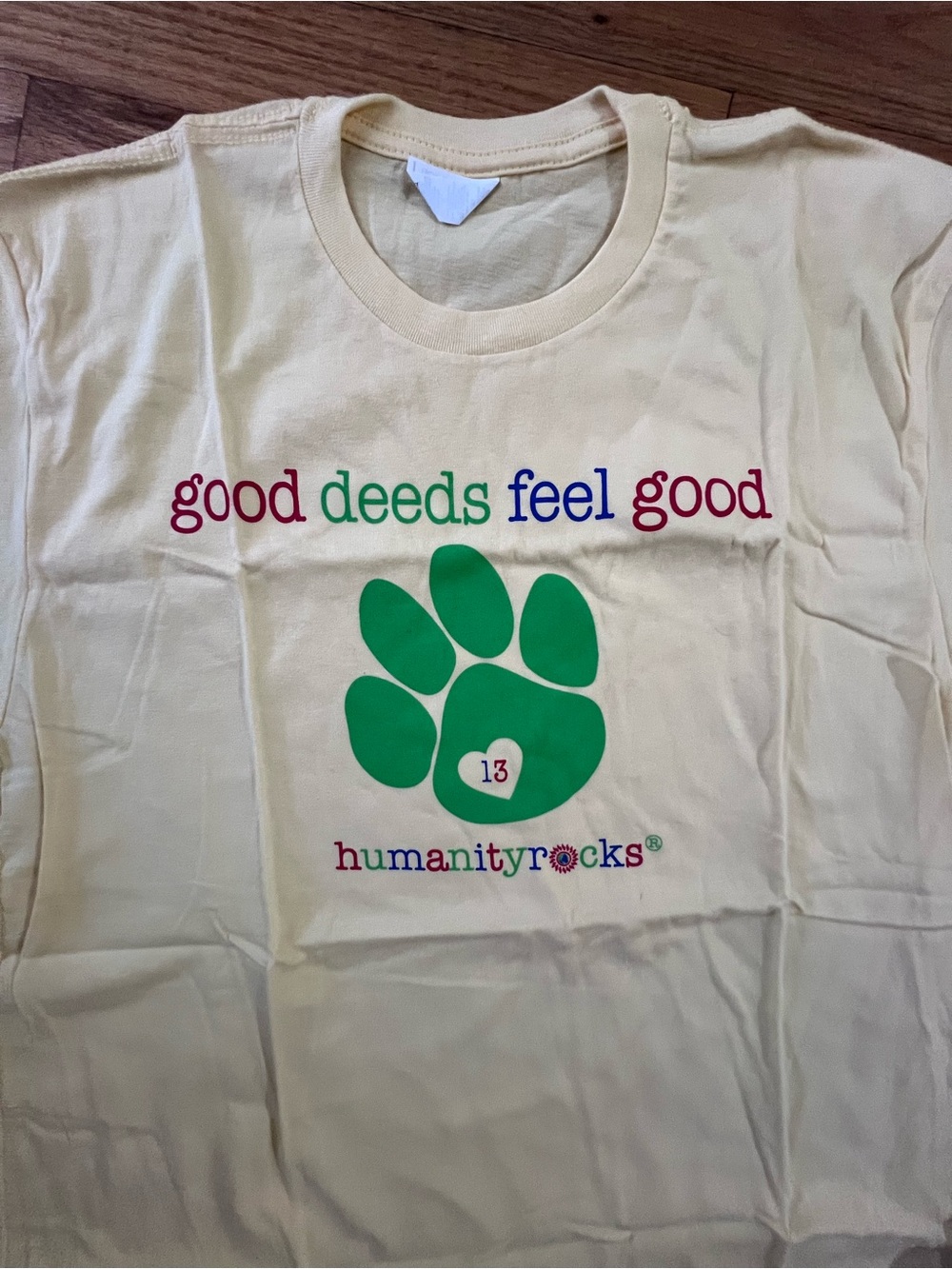 Next Level Apparel Cream Tee with Green Paw & Multicolor Text